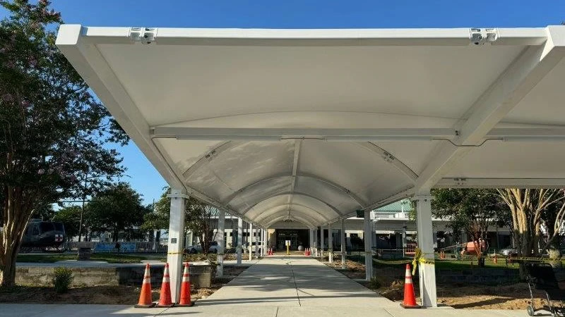 A covered walkway featuring freshly coated white steel beams and arched roof, exemplifying the industrial coating services provided, including powder coating and liquid coating, for strong and weather-resistant outdoor structures.